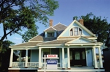 House with Coldwell Banker Sold yard sign in front.