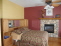 Master bedroom with hardwood floors and see through fireplace w stone surround no image